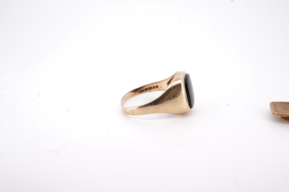 A 1980's 9ct gold tie clip, 39mm and a similar 9ct gold and black onyx set signet ring, gross weight 10 grams.